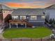 Landscaped backyard with a wooden deck, lush green lawn, and a house with gray siding at 20795 Scenic Park Dr, Parker, CO 80138