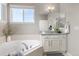 Bright bathroom featuring a soaking tub, granite countertop, and soft-close cabinets at 20795 Scenic Park Dr, Parker, CO 80138