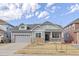 Inviting two-story home featuring gray siding, stone accents, an attached garage, and a charming covered front porch at 20795 Scenic Park Dr, Parker, CO 80138