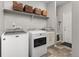 Spacious laundry room with front-load washer and dryer and convenient storage options at 20795 Scenic Park Dr, Parker, CO 80138