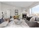 Bright living room featuring a fireplace, large windows, and stylish furnishings on a hardwood floor at 20795 Scenic Park Dr, Parker, CO 80138