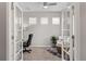 Home office with modern glass french doors, neutral carpet, and sun-filled windows at 20795 Scenic Park Dr, Parker, CO 80138