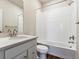 Clean bathroom featuring a shower over bath, white tile, and a bright sink at 14366 Heritage Dr, Mead, CO 80504