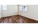 Bright bedroom featuring hardwood floors, neutral walls, and natural light from two windows at 14366 Heritage Dr, Mead, CO 80504