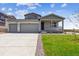 Charming home features a two-car garage, covered porch, and manicured lawn with beautiful landscaping at 14366 Heritage Dr, Mead, CO 80504