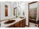 Elegant bathroom with double sinks, arched mirrors, and decorative tile countertops at 5904 Meadowbrook Dr, Morrison, CO 80465
