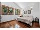 Cozy bedroom with hardwood floors, multiple windows, and stylish sconce lighting at 5904 Meadowbrook Dr, Morrison, CO 80465