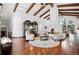 Bright and spacious living room featuring high ceilings, exposed beams, a unique fireplace, and elegant furnishings at 5904 Meadowbrook Dr, Morrison, CO 80465