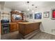Basement bar area with wooden bar and cabinets, plus a beverage fridge and decorative lighting at 6321 Spotted Fawn Run, Littleton, CO 80125