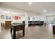 Finished basement with an open layout, featuring a foosball table, bar, and comfortable seating area at 6321 Spotted Fawn Run, Littleton, CO 80125
