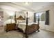 Bedroom with ornate four-poster bed, side tables, and large window with a backyard view at 6321 Spotted Fawn Run, Littleton, CO 80125