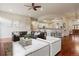 Spacious living room with a leather couch, white arm chairs, and access to the open kitchen at 6321 Spotted Fawn Run, Littleton, CO 80125