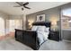 Comfortable main bedroom with a ceiling fan and an open doorway to the ensuite bathroom at 6321 Spotted Fawn Run, Littleton, CO 80125