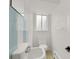Small bathroom featuring a white sink, toilet, tiled wall, and a window at 1149 Columbine St # 202, Denver, CO 80206