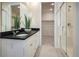 Modern bathroom featuring dual sinks, sleek black countertops, a glass-enclosed shower, and a walk-in closet at 23751 E 40Th Ave, Aurora, CO 80019
