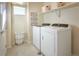 Functional laundry room with modern washer and dryer, shelving, and ample space for laundry needs at 23751 E 40Th Ave, Aurora, CO 80019