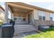 Back porch with a view of grass and the house's brick foundation, perfect for relaxing in the outdoors at 24197 E Ada Ave, Aurora, CO 80018