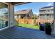 View from the home's rear deck showcasing the lush green backyard, wood fence, and neighboring homes at 24197 E Ada Ave, Aurora, CO 80018