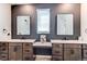 Stylish bathroom featuring double sinks, modern fixtures, and a unique peacock art piece between the mirrors at 24197 E Ada Ave, Aurora, CO 80018