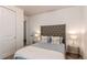 Bright bedroom featuring a tufted headboard, stylish side tables with lamps, and decorative pillows at 24197 E Ada Ave, Aurora, CO 80018