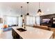 Open kitchen featuring sleek island with sink, pendant lighting, and combined living and dining spaces at 24197 E Ada Ave, Aurora, CO 80018