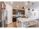 Modern kitchen with stainless appliances, quartz countertops, dark cabinetry, and pendant lighting at 24197 E Ada Ave, Aurora, CO 80018