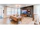 Open concept living room featuring stylish furniture, large windows with sheer curtains and decorative art at 24197 E Ada Ave, Aurora, CO 80018