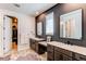 Main bathroom featuring double sinks, modern fixtures, and a glass-enclosed shower with a neutral color palette at 24197 E Ada Ave, Aurora, CO 80018