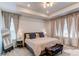 Main bedroom featuring a tray ceiling, large window, and neutral decor with carpet flooring at 24197 E Ada Ave, Aurora, CO 80018