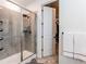 Bright shower featuring a large glass door, tiled walls, and a view of the attached walk-in closet at 24197 E Ada Ave, Aurora, CO 80018