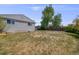A spacious backyard with green grass leads to a home with light gray siding at 6924 S Albion St, Centennial, CO 80122