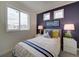 Cozy bedroom features a bright window, and a navy accent wall with stylish decor at 10346 Uvalda Ave, Commerce City, CO 80022