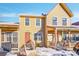 Tan two-story townhome with orange door and small porch at 10537 W Maplewood # B, Littleton, CO 80127