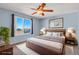 Bright bedroom with light blue walls, ceiling fan, and a window with a scenic view at 5521 S Yakima St, Aurora, CO 80015