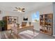 Home office featuring natural light, a ceiling fan and built-in bookcases for storage at 5521 S Yakima St, Aurora, CO 80015