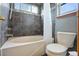 Tiled bathroom with a shower-tub combination and a toilet under a window at 8791 Starwood Ln, Parker, CO 80134
