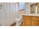 Bright bathroom featuring a window, light wood vanity, and a shower with a white curtain at 8791 Starwood Ln, Parker, CO 80134