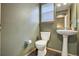 Cozy half bathroom with a pedestal sink, toilet, mirror, and window at 8791 Starwood Ln, Parker, CO 80134