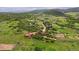 Aerial view of rolling hills with scattered homes and a winding road through the verdant landscape at 3850 Hopi Dr, Sedalia, CO 80135