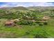 Wide aerial shot of a rural community with houses nestled among rolling hills and lush greenery at 3850 Hopi Dr, Sedalia, CO 80135