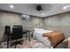 Basement bedroom featuring an unfinished concrete wall, bed, and desk at 3850 Hopi Dr, Sedalia, CO 80135