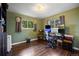 Green bedroom featuring hardwood floors, natural light, and a desk setup at 3850 Hopi Dr, Sedalia, CO 80135