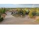 Scenic view of a tan ranch home, landscaped front yard, attached garage, and expansive fields with a rainbow in the background at 3850 Hopi Dr, Sedalia, CO 80135