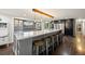 A modern kitchen features an expansive island with counter seating, stainless steel appliances, and dark cabinetry at 3850 Hopi Dr, Sedalia, CO 80135