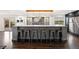Stylish kitchen island with barstool seating, wine storage, and modern light fixtures overlooking the backyard at 3850 Hopi Dr, Sedalia, CO 80135