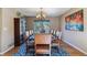 Elegant dining room featuring a large table with seating for eight, a chandelier, and hardwood flooring at 474 Rose Finch Cir, Highlands Ranch, CO 80129
