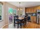 Bright dining area features a chandelier, table and chairs, wood floors, and access to the deck at 474 Rose Finch Cir, Highlands Ranch, CO 80129