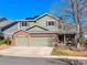 Charming two-story home with a two-car garage, brick accents, and solar panels against a clear, blue sky at 474 Rose Finch Cir, Highlands Ranch, CO 80129