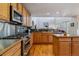 Well-lit kitchen boasts a gas range, stainless appliances, dark stone backsplash, island and hardwood floors at 474 Rose Finch Cir, Highlands Ranch, CO 80129