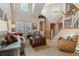 Open living room with high ceilings, a staircase with white railings, and abundant natural light, creating an airy atmosphere at 474 Rose Finch Cir, Highlands Ranch, CO 80129